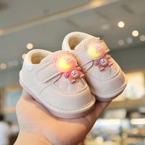 Cute pink baby walking shoes with glowing cartoon monster decoration and soft rubber soles