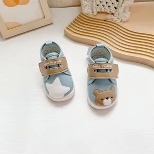 Detail van blauwe baby loopschoenen met schattige ster- en beerborduurpatronen