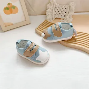 Detailweergave van lichtblauwe babyschoentjes met schattige patches en zachte witte zolen.