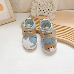 Gedetailleerde weergave van schattige babyloopschoenen met beer- en sterborduurwerk.