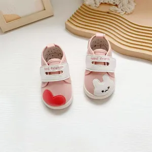 Detailopname van roze baby loopschoenen met schattig hart en konijn borduursel.