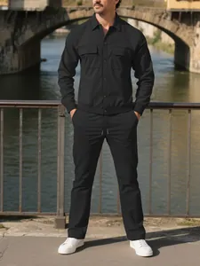 Full-length view of a men's black corduroy two-piece set in an outdoor urban setting.