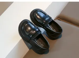 Vue détaillée en plongée de mocassins en cuir noir brillant pour filles à semelles souples