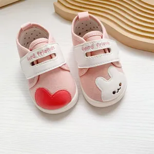 Gedetailleerd beeld van roze baby loopschoentjes met hart en konijn patches