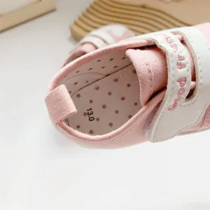 Detailopname van de roze baby-loopschoen met maattabel en schattig sterrenpatroon