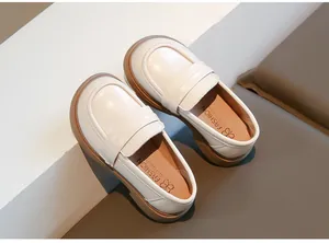 Gros plan de mocassins JK blancs crème élégants pour filles avec semelles souples.
