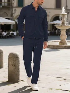 Full body detail of men's navy blue corduroy set shown in an outdoor urban setting