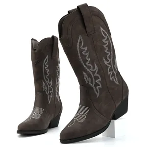 Detailed macro view of women's dark brown cowboy boots with intricate white western embroidery