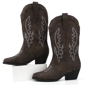 Detail shot of dark brown women's cowboy boots with white embroidery and block heel.
