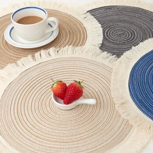 Top view of round woven cotton placemats with fringe details featuring a coffee cup and strawberries