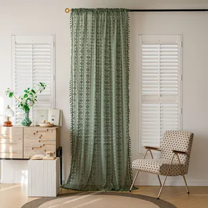 Dettaglio della tenda all'uncinetto verde con eleganti bordi a nappine