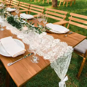 Detailed macro view of white lace table runner with floral embroidery on wooden table decor