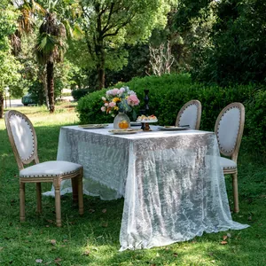 Elegant white lace tablecloth featuring floral patterns for outdoor wedding decoration.