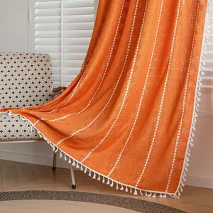 Detailed view of orange semi-blackout curtain featuring white heart patterns and tassels