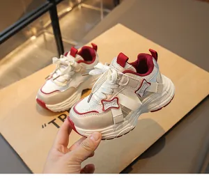 Detail of girls' breathable chunky sneakers with stylish red accents and bow decor.