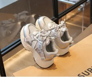 Detailed close-up of silver metallic mesh sneakers for girls featuring star-shaped accents.