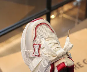 Detailed macro view of girls' breathable mesh sneakers with a glittery red bow accent