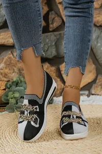 Vista detallada de mocasines flyknit en blanco y negro para mujer con hebilla de cristales.