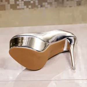 Close-up of silver metallic high heel stiletto with thick platform and textured sole.