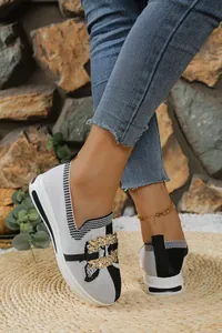 Primer plano de mocasines de punto en blanco y negro con hebilla de metal dorado