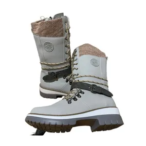 Detailed view of light grey mid-calf riding boots with knit cuff and decorative buckle