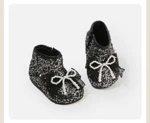 Detail van baby wandellaarzen met sprankelende pailletten en elegante parelstriks.
