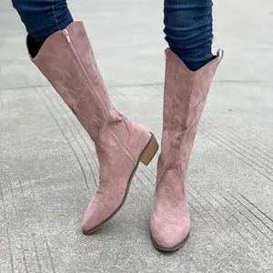 Close-up detail of pink suede western boots featuring embroidery and classic V-cut design