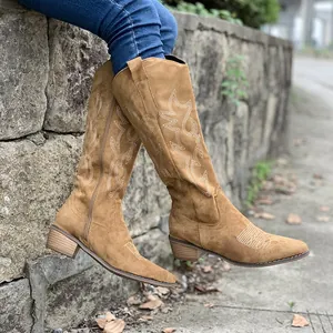 Close-up of vintage embroidered tan mid-calf western cowboy boots with chunky heel.