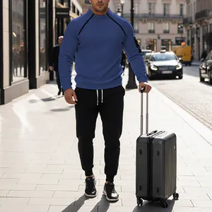 Outdoor view of a man wearing a blue coral fleece tracksuit set while holding a suitcase