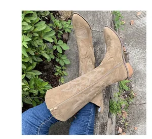Vintage tan suede Western cowboy boots with intricate embroidery and a classic chunky heel.