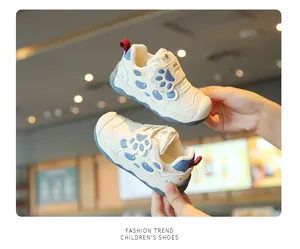 Detailaufnahme der beigen Lauflernschuhe mit süßem blauen Cartoon-Pfotenabdruck-Design
