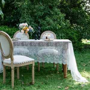Detailed view of a white lace tablecloth with elegant floral patterns in the garden