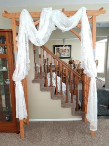 French style white lace veil with 3D floral embroidery draped on a wooden arch