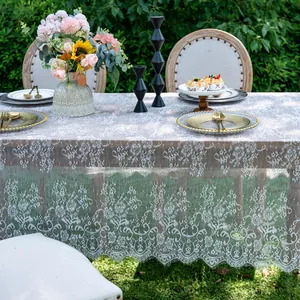Detailed macro view of elegant white lace tablecloth with delicate floral embroidery patterns