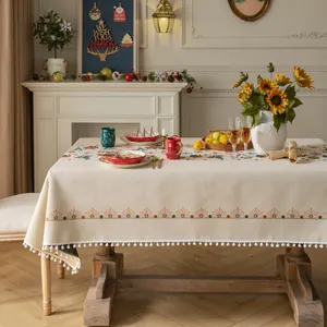 Tovaglia jacquard natalizia con bordi a pompon in un accogliente ambiente domestico