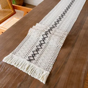Détail du chemin de table bohème en coton tissé avec motifs géométriques et franges