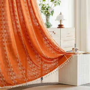 Detailed view of orange textured semi-blackout curtain with white fringe tassels.