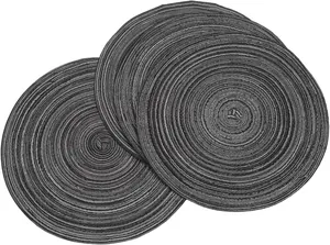 Close-up view of dark grey woven round placemats with spiral texture for kitchen dining table decor