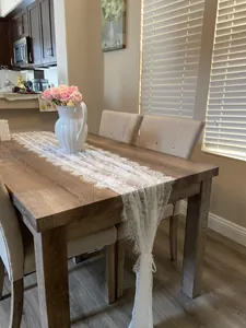 Elegant French white lace table runner with floral embroidery in a cozy dining room