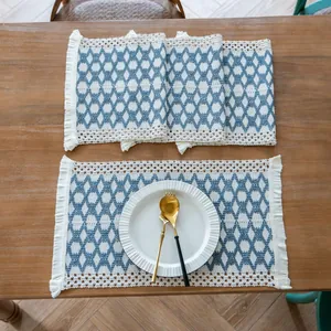 Close-up detail of a farmhouse woven placemat with blue diamond pattern and elegant fringes