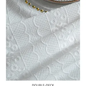 Close-up of French white embroidered lace tablecloth with delicate floral texture