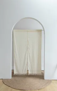 Minimalist Japanese noren door curtain featuring orange polka dots and elegant tassel fringe