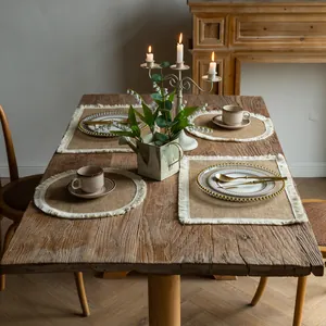 Rustic farmhouse dining setup featuring jute fringe placemats and warm candle lighting