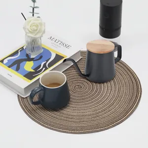 Close-up of a rustic round woven placemat with coffee mug and kettle setup
