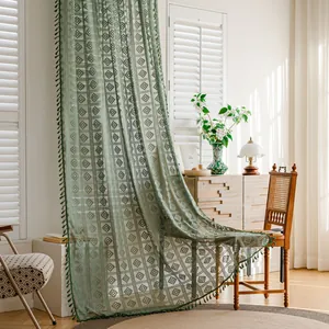 Elegante tenda in pizzo all'uncinetto verde con frange in un soggiorno luminoso.