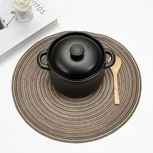 Close-up of woven round placemat with rustic brown spiral texture under a black pot