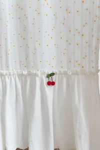 Detail view of cotton door curtain with ruffled edge and cherry applique decoration