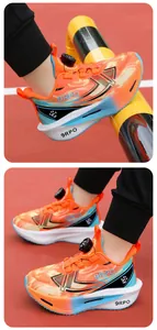 Detailed view of boys orange gradient sneakers with mechanical rotating buckle system.