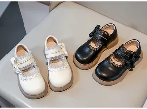 Detalle de zapatos Lolita de cuero para niñas en blanco y negro con lazos de encaje