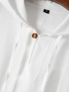 Detailweergave van een witte katoenen herentop met capuchon en een stijlvolle knoop.
